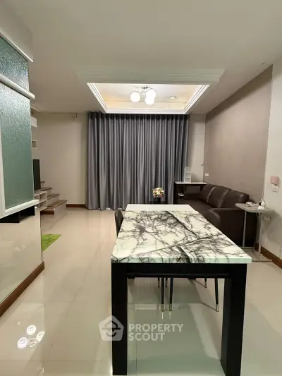 Modern living room with marble dining table and elegant lighting, perfect for stylish urban living.
