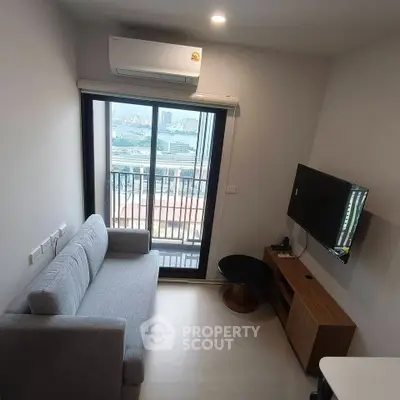 Modern living room with balcony view, featuring a sleek sofa and wall-mounted TV in a compact space.