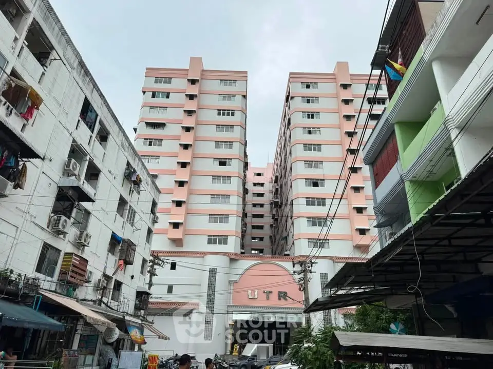Charming pink and white residential building with urban surroundings, ideal for city living.