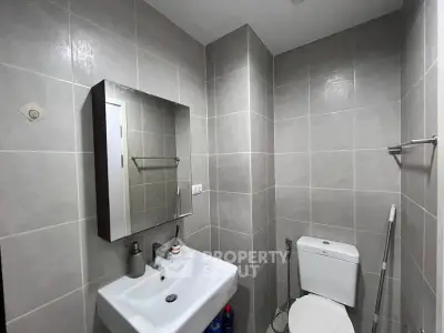 Modern bathroom with sleek fixtures and tiled walls in a contemporary apartment.