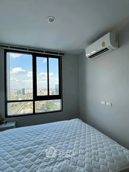 Modern bedroom with city view and air conditioning in high-rise apartment