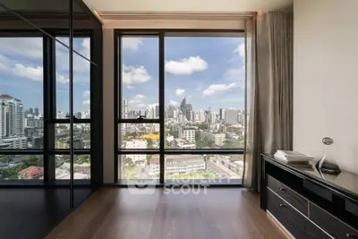 Stunning city view from modern high-rise apartment with floor-to-ceiling windows and sleek interior design.