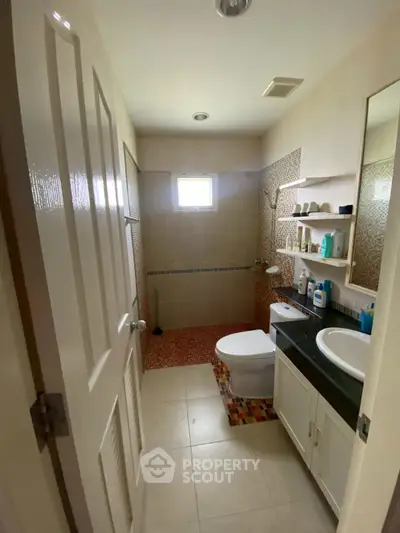 Cozy bathroom with modern fixtures and ample storage space.