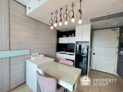 Modern kitchen with stylish lighting and sleek appliances in a contemporary apartment.