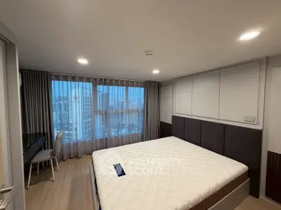 Spacious bedroom with city view, featuring modern decor and large windows for natural light.