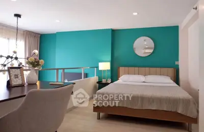 Modern bedroom with teal accent wall and stylish decor, featuring a cozy bed and elegant desk area.