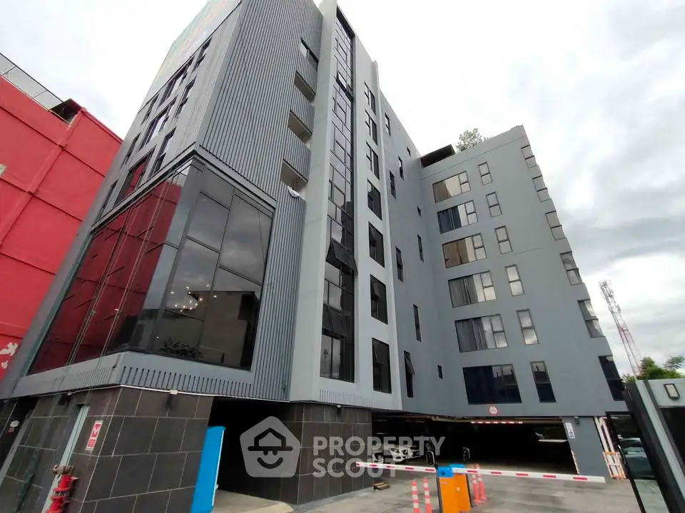 Modern multi-story building with sleek design and large windows, showcasing urban architecture.