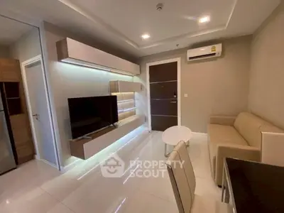 Modern living room with sleek furniture and wall-mounted TV in a stylish apartment.