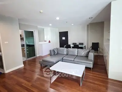 Spacious modern living room with sleek furniture and wooden flooring in a stylish apartment.