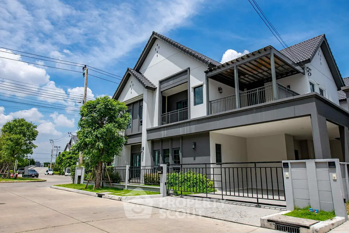 Modern two-story house with spacious driveway and lush greenery in a suburban neighborhood.