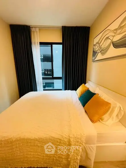 Cozy bedroom with modern decor and large window in a stylish apartment.