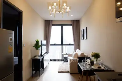Modern living room with elegant chandelier and city view, featuring cozy seating and stylish decor.
