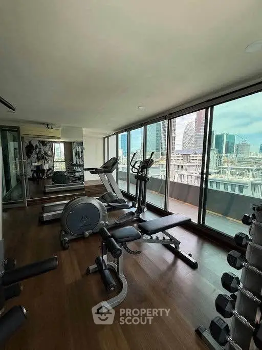 Luxurious high-rise gym with panoramic city views and modern fitness equipment.