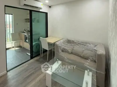 Modern living room with glass coffee table and compact kitchen area