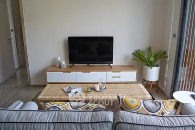 Modern living room with stylish decor and flat-screen TV, featuring a cozy sofa and elegant coffee table.
