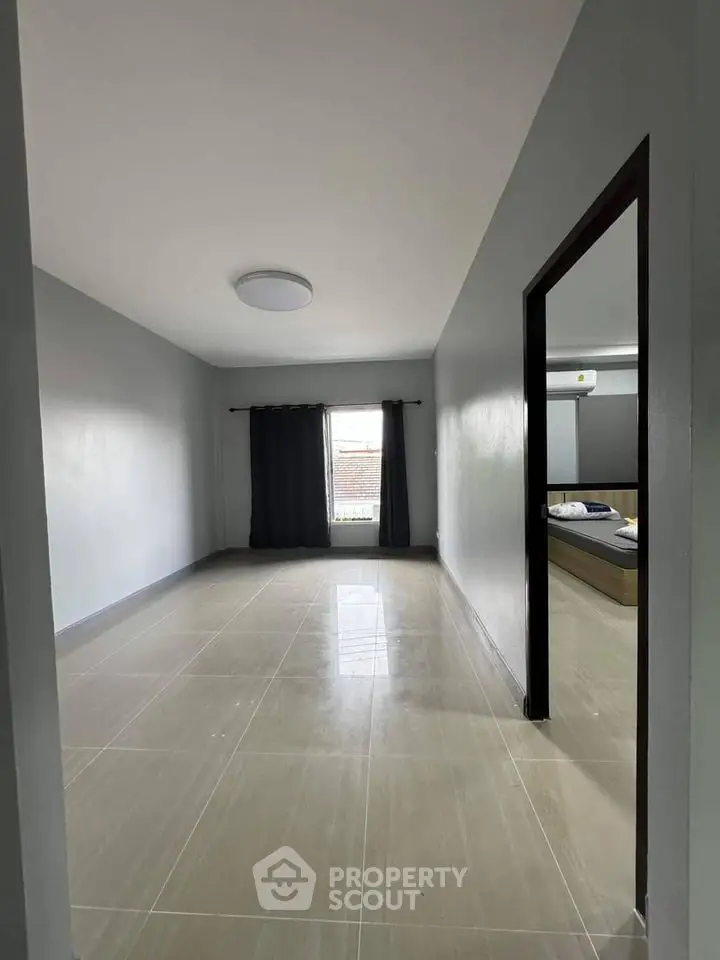 Spacious unfurnished room with tiled flooring and natural light