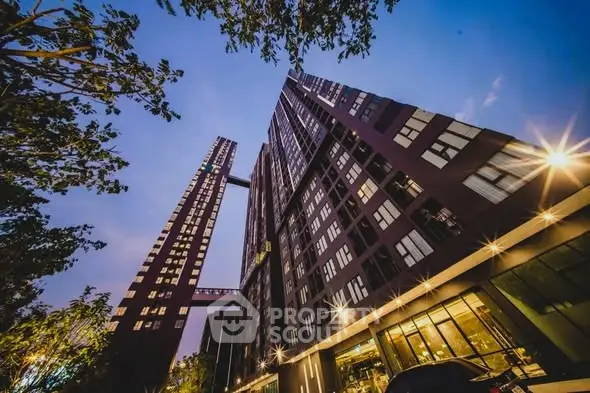 Stunning modern high-rise building with unique architectural design and illuminated facade at dusk.
