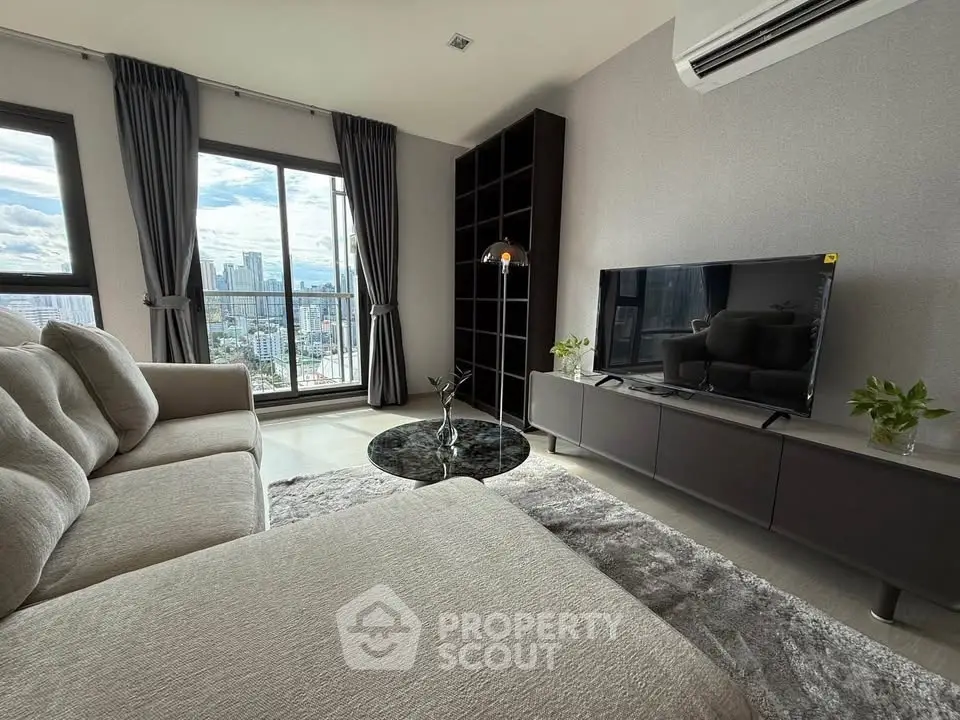 Modern living room with city view, stylish furniture, and large windows for natural light.