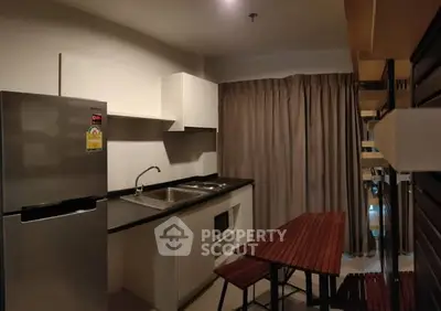 Modern kitchen with sleek appliances and dining area in cozy apartment