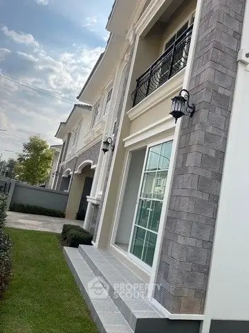 Elegant two-story house exterior with stone facade and manicured lawn