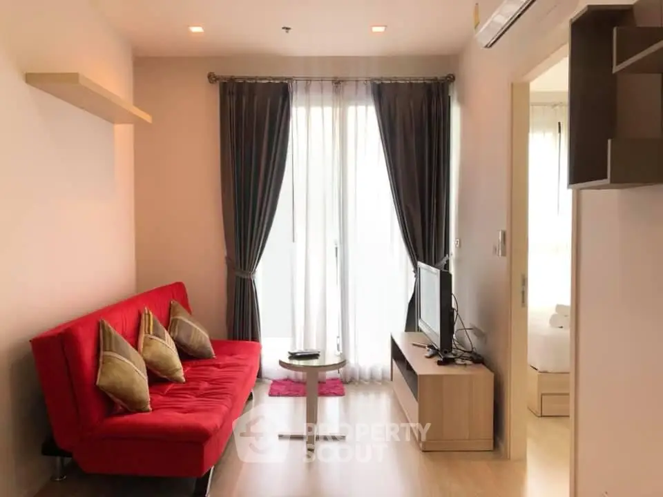 Modern living room with red sofa, TV, and large window with curtains in a stylish apartment.