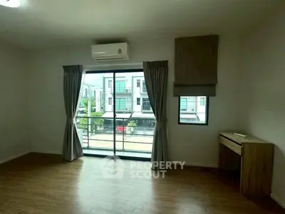 Spacious living room with large window and balcony view in modern apartment.