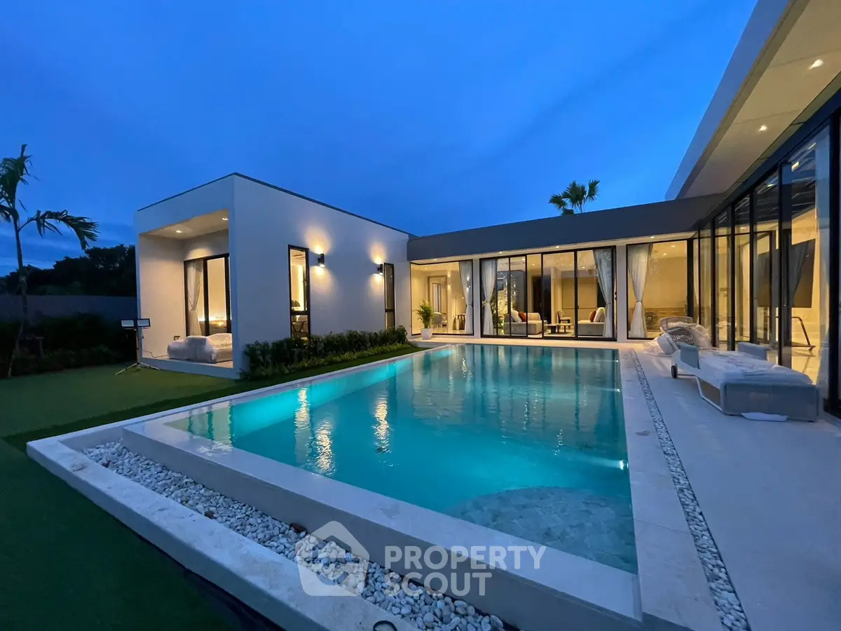 Luxurious modern villa with stunning pool and elegant outdoor lighting at dusk.