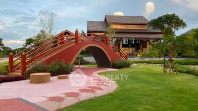 Charming garden with arched bridge and modern house, perfect for serene living.