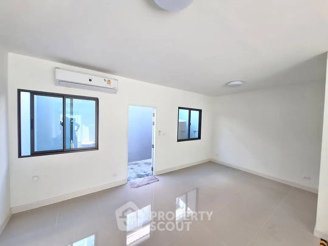 Spacious unfurnished room with large windows and air conditioning unit