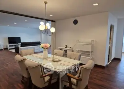 Spacious open-plan living and dining area with elegant lighting and modern furnishings.