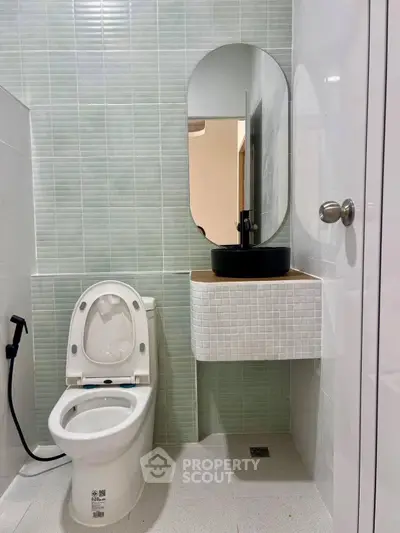 Modern bathroom with sleek design and stylish fixtures, featuring a contemporary toilet and elegant sink.