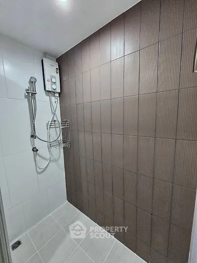 Modern bathroom with sleek shower and stylish brown accent wall tiles.