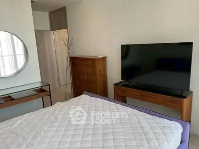 Modern bedroom with stylish furniture and large TV, perfect for relaxation and comfort.