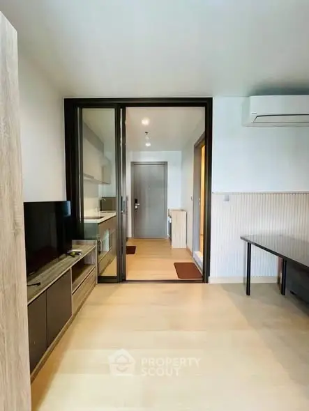 Modern living room with sliding glass doors and air conditioning in a stylish apartment.