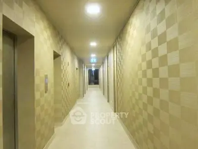 Modern apartment building hallway with checkered wallpaper and bright lighting.