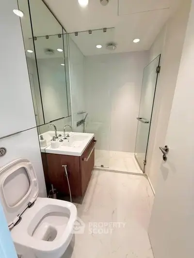 Modern bathroom with sleek design, glass shower, and elegant fixtures in a contemporary apartment.