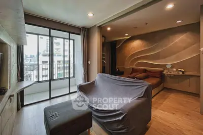 Modern living room with balcony and city view, featuring stylish decor and cozy seating area.