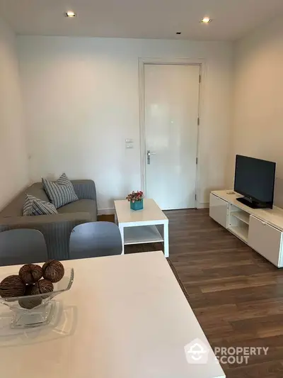 Modern living room with cozy sofa, TV, and stylish decor in a contemporary apartment.