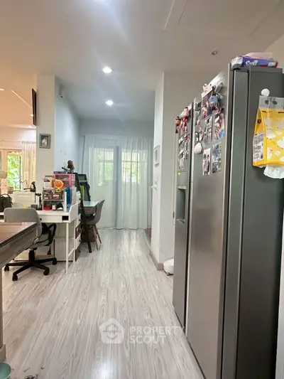 Modern kitchen with sleek fridge and open layout, perfect for family gatherings.