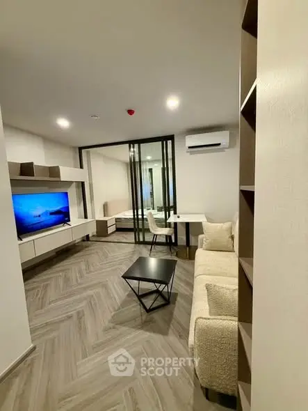 Modern living room with sleek design and glass partition, featuring cozy seating and stylish decor.