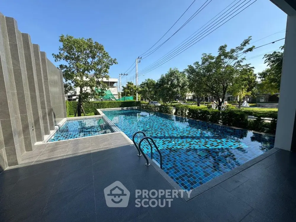 Luxurious outdoor pool with modern design and lush greenery, perfect for relaxation and leisure.