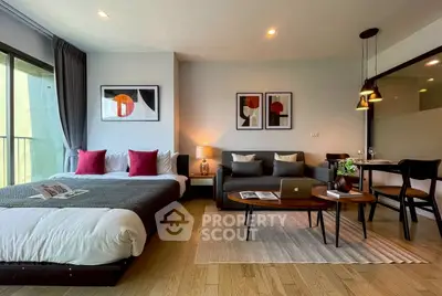 Modern studio apartment with stylish decor, featuring a cozy bed, chic sofa, and elegant dining area.