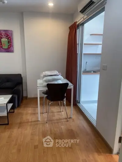 Cozy living area with wooden flooring and compact dining space