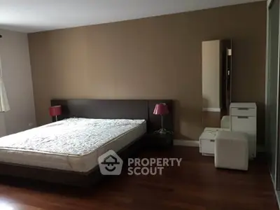 Spacious bedroom with modern furniture and wooden flooring