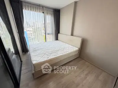 Modern bedroom with large window and city view, featuring a comfortable bed and stylish decor.