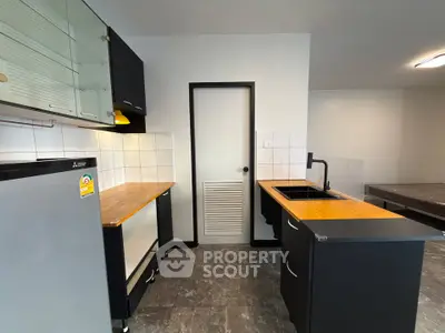 Modern kitchen with sleek black cabinets and wooden countertops
