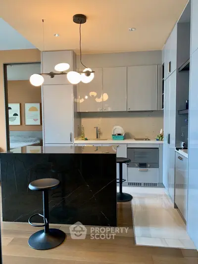 Modern kitchen with sleek cabinetry and stylish lighting in a contemporary apartment.