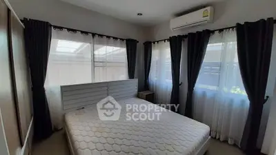 Cozy bedroom with natural light and air conditioning, perfect for relaxation.