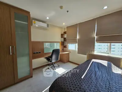 Modern bedroom with built-in desk and large window offering city views