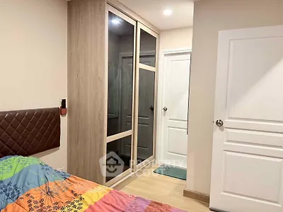Cozy bedroom with modern wardrobe and colorful bedding in a stylish apartment.